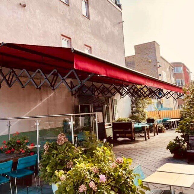 Het terras onder de rode luifel