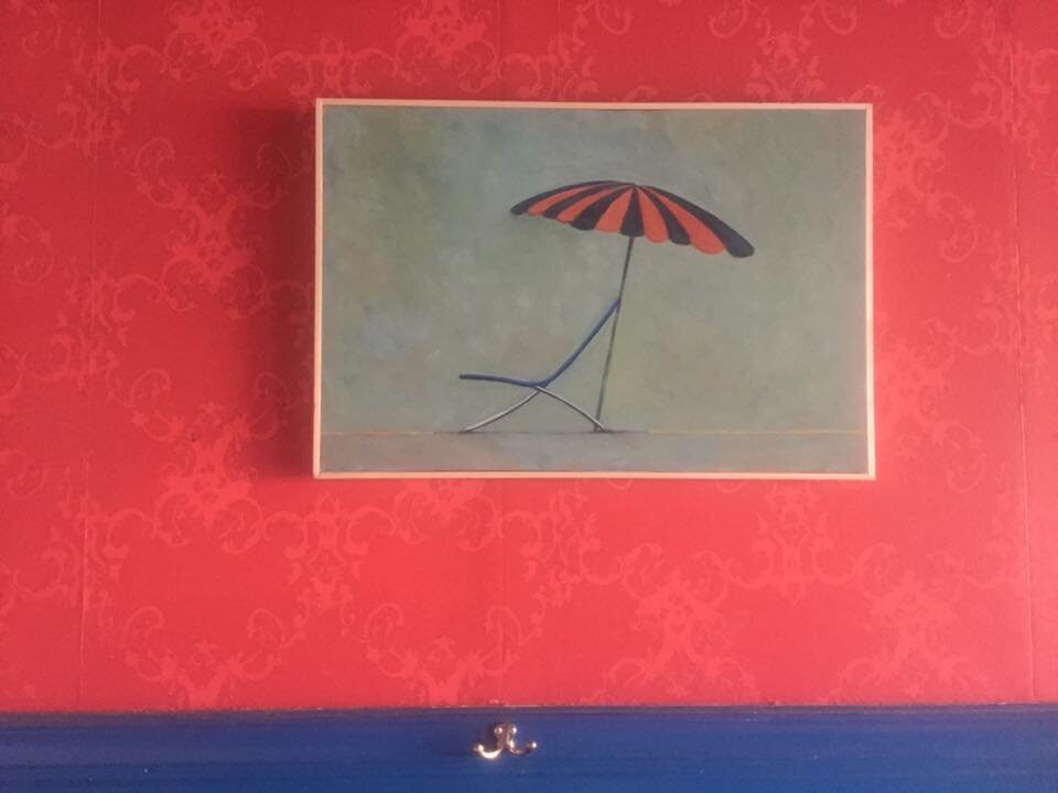 Schilderij met parasol op een rode muur
